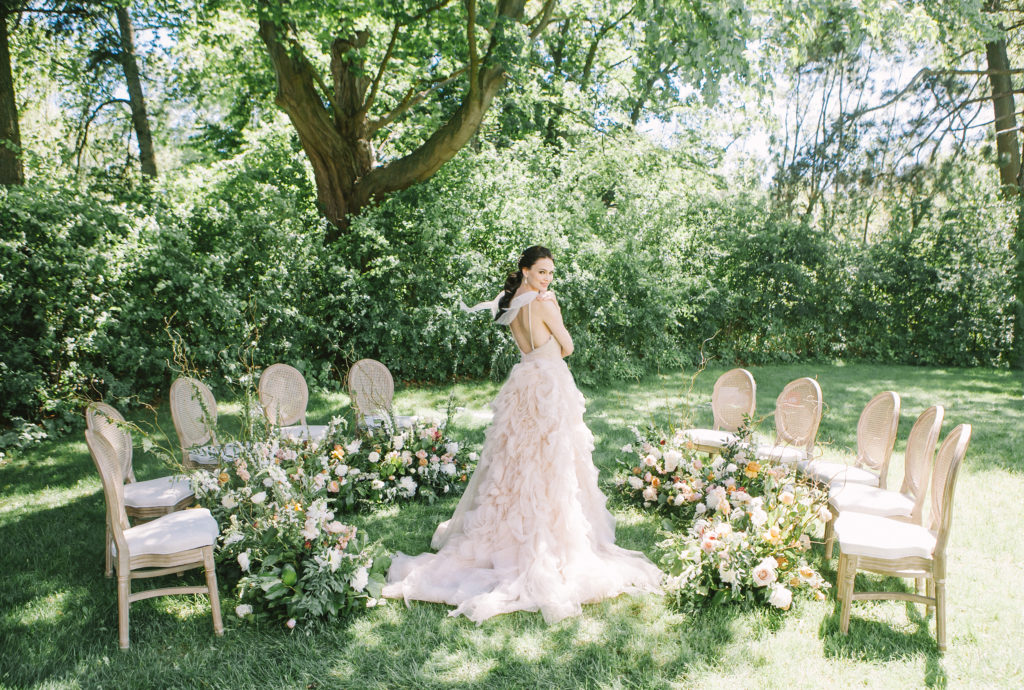 Bride standing in the middle of chairs and flowers  | Weddings & Events by Cheryl Munro | Toronto Wedding Planner