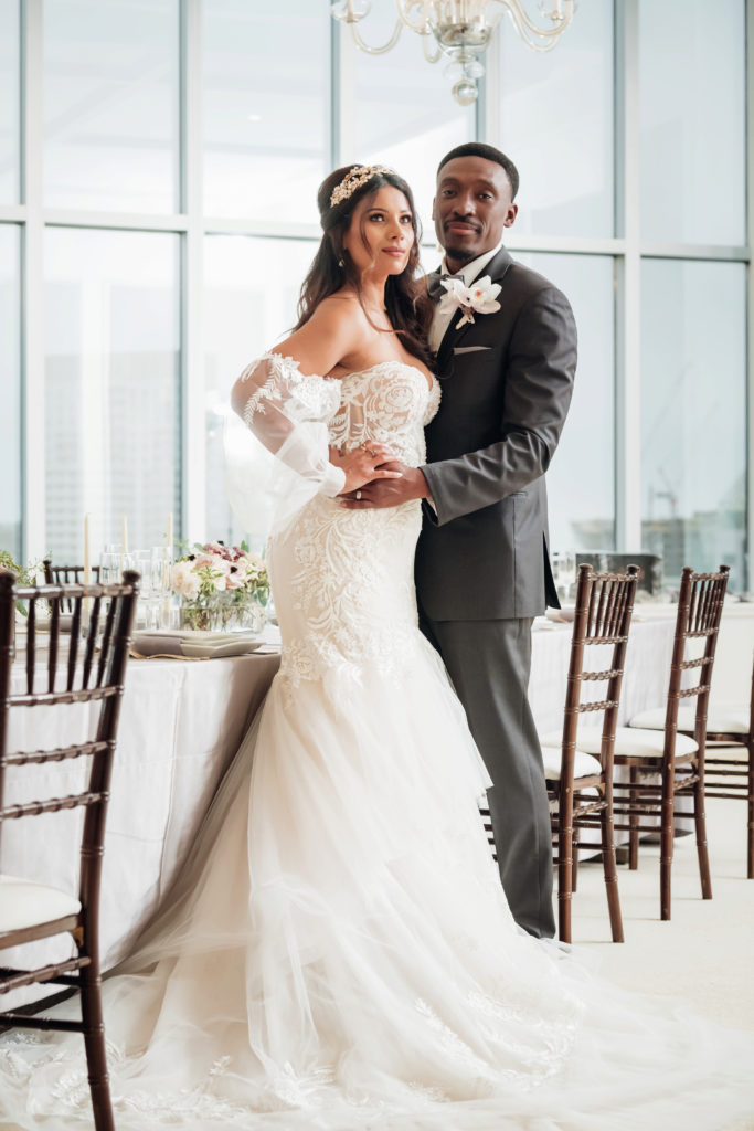Bride and groom standing together closer with decorated table behind them | Weddings & Events by Cheryl Munro | Toronto Wedding Planner