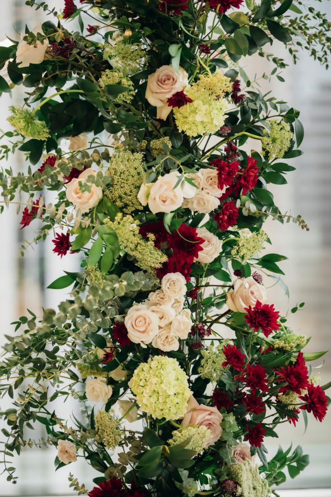Close up of floral arch that has white, cream and burgundy flowers | Weddings & Events by Cheryl Munro | Toronto Wedding Planner