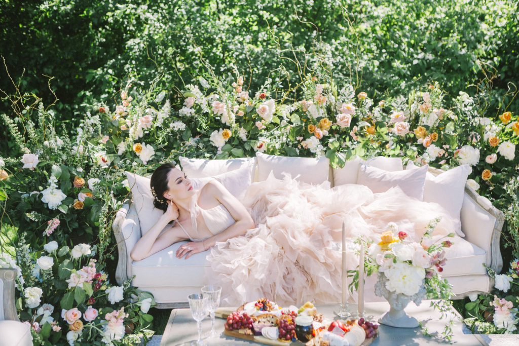 Bride laying on couch surrounded by flowers  | Weddings & Events by Cheryl Munro | Toronto Wedding Planner
