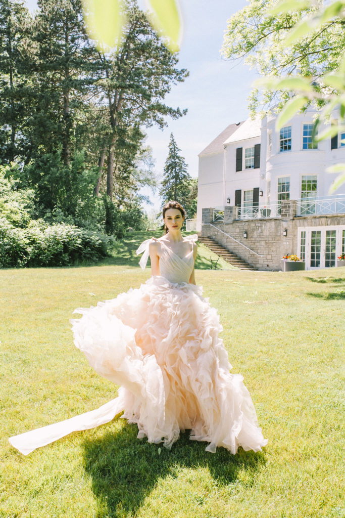 Bride walking with Harding Waterfront Estate in the background  | Weddings & Events by Cheryl Munro | Toronto Wedding Planner