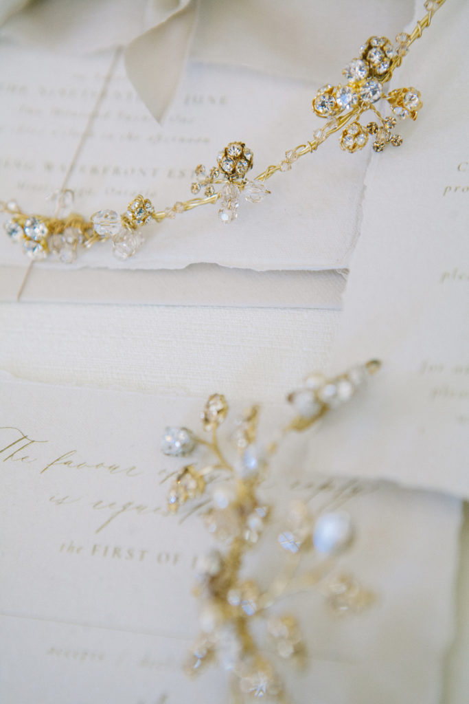 Gold hair jewellery on top of wedding stationery  | Weddings & Events by Cheryl Munro | Toronto Wedding Planner