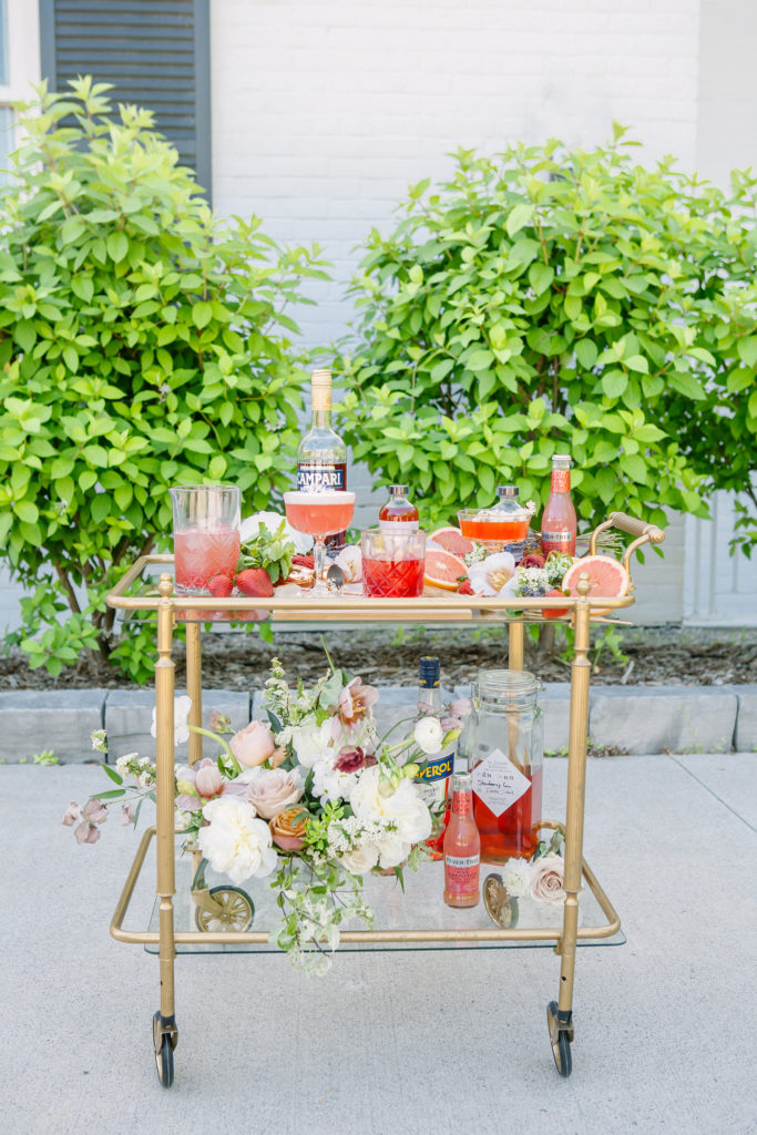 Bar cart with orange drinks and fruit and flowers | Weddings & Events by Cheryl Munro | Toronto Wedding Planner
