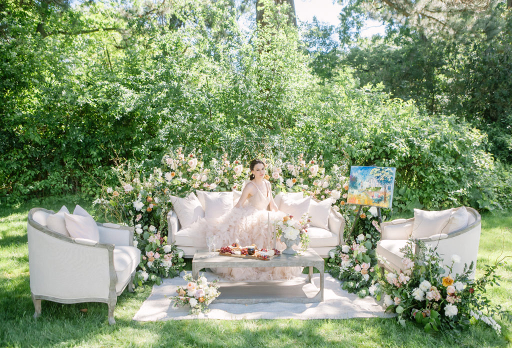 Bride sitting on lounge furniture with flowers and artwork  | Weddings & Events by Cheryl Munro | Toronto Wedding Planner