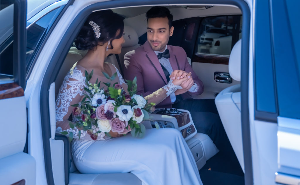 Bride and groom in rolls royce holding hands  | Weddings & Events by Cheryl Munro | Toronto Wedding Planner