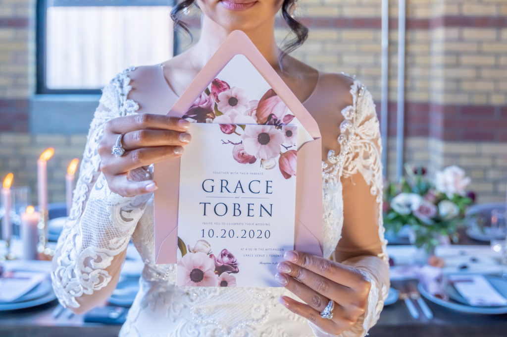 Bride holding up pink and floral wedding invitation  | Weddings & Events by Cheryl Munro | Toronto Wedding Planner