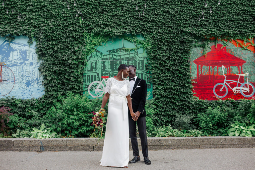 Couple in city streets holding rustic floral bouquet| Weddings & Events by Cheryl Munro | Toronto Wedding Planner