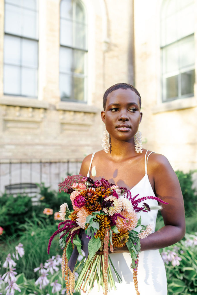 Bride in city streets holding rustic floral bouquet| Weddings & Events by Cheryl Munro | Toronto Wedding Planner