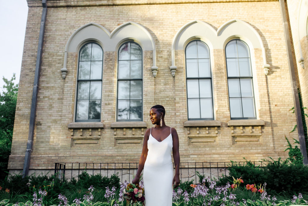 Bride standing in front of old building  | Weddings & Events by Cheryl Munro | Toronto Wedding Planner