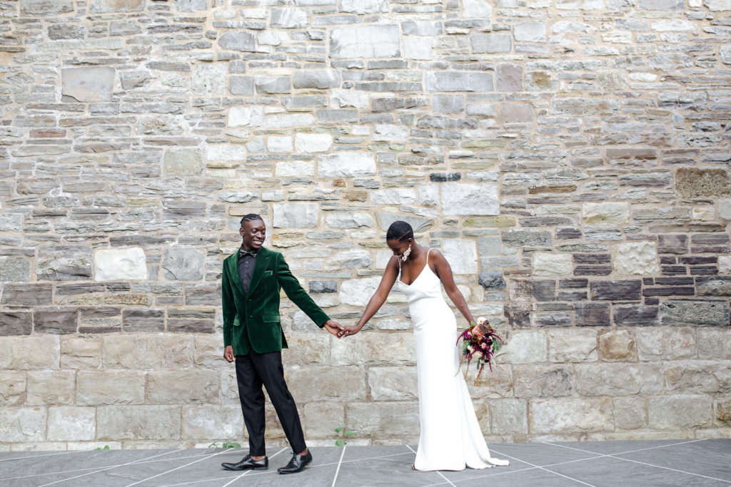 Couple in city streets holding rustic floral bouquet| Weddings & Events by Cheryl Munro | Toronto Wedding Planner