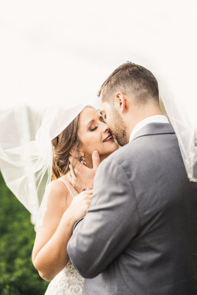 Bride and groom about to kiss underneath veil | Weddings & Events by Cheryl Munro | Toronto Wedding Planner