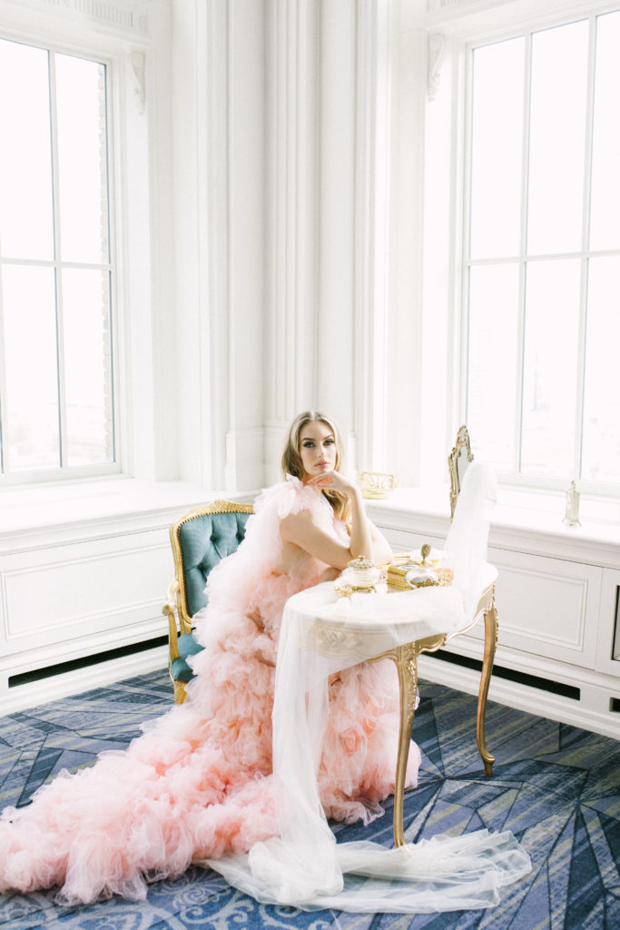 Bride in pink ruffle dress sitting at mirror | Weddings & Events by Cheryl Munro | Toronto Wedding Planner