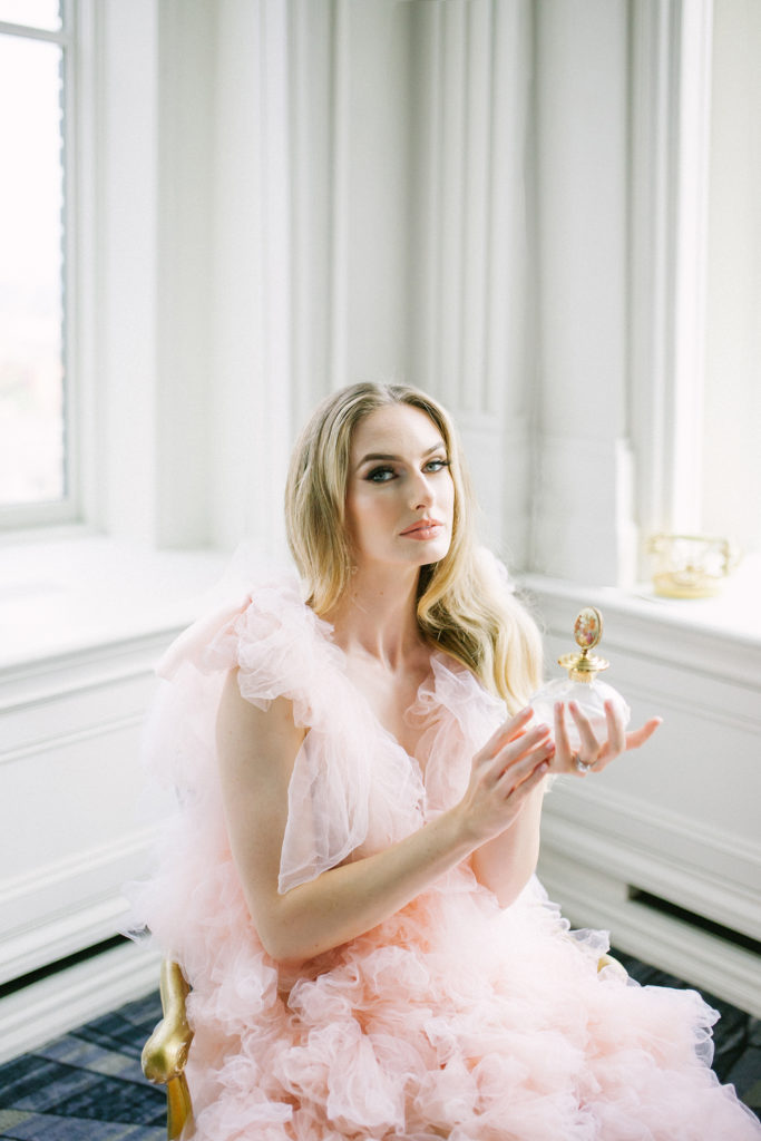 Bride in pink ruffle dress holding perfume bottle  | Weddings & Events by Cheryl Munro | Toronto Wedding Planner