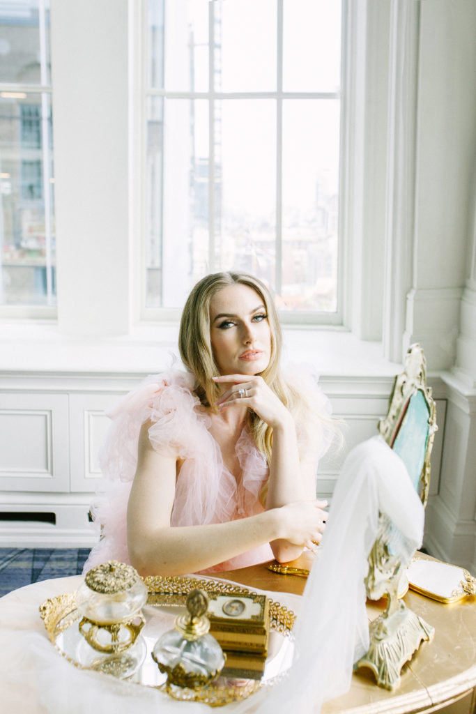 Bride in pink ruffle dress sitting at vanity | Weddings & Events by Cheryl Munro | Toronto Wedding Planner