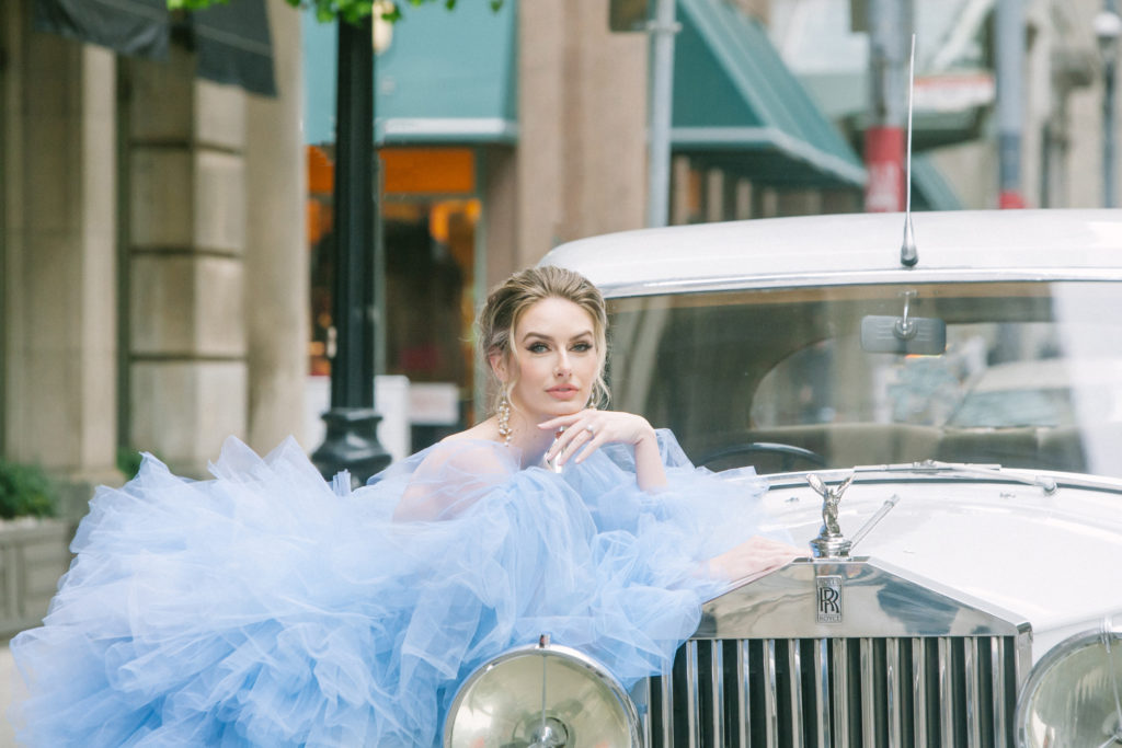 Bride in blue ruffle dress leaning against a rolls royce  | Weddings & Events by Cheryl Munro | Toronto Wedding Planner