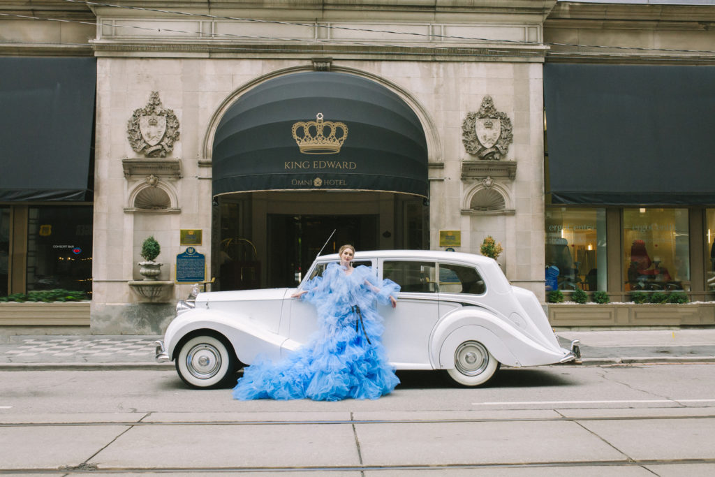 Bride in blue ruffle dress standing in front of the King Edward Omni Hotel and a rolls royce  | Weddings & Events by Cheryl Munro | Toronto Wedding Planner