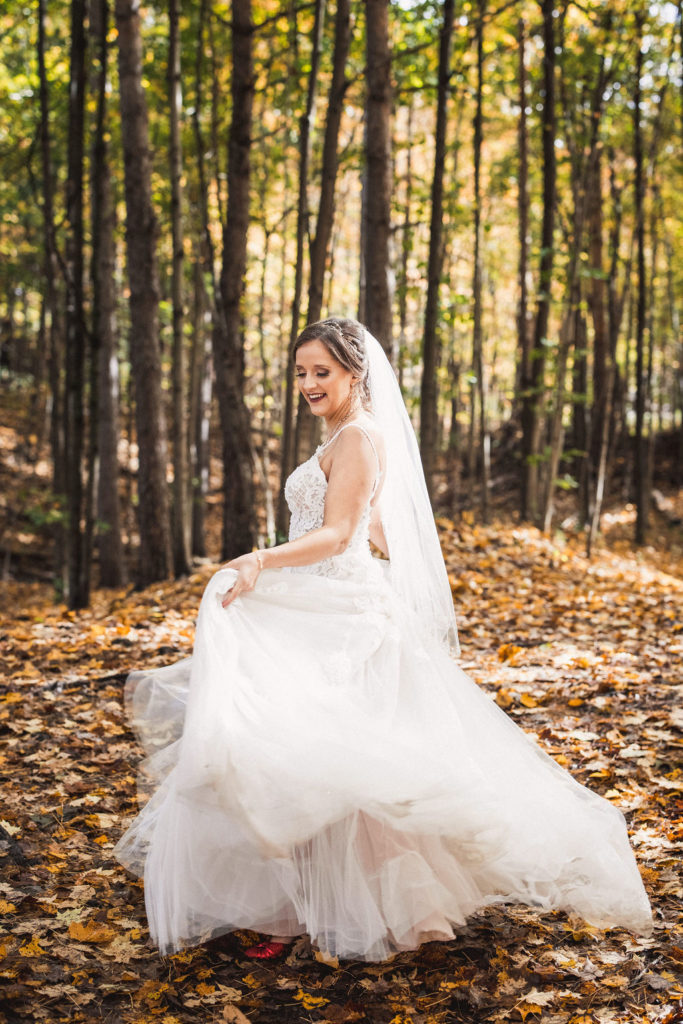 Bride twirling dress in a forest with fallen leaves | Weddings & Events by Cheryl Munro | Toronto Wedding Planner